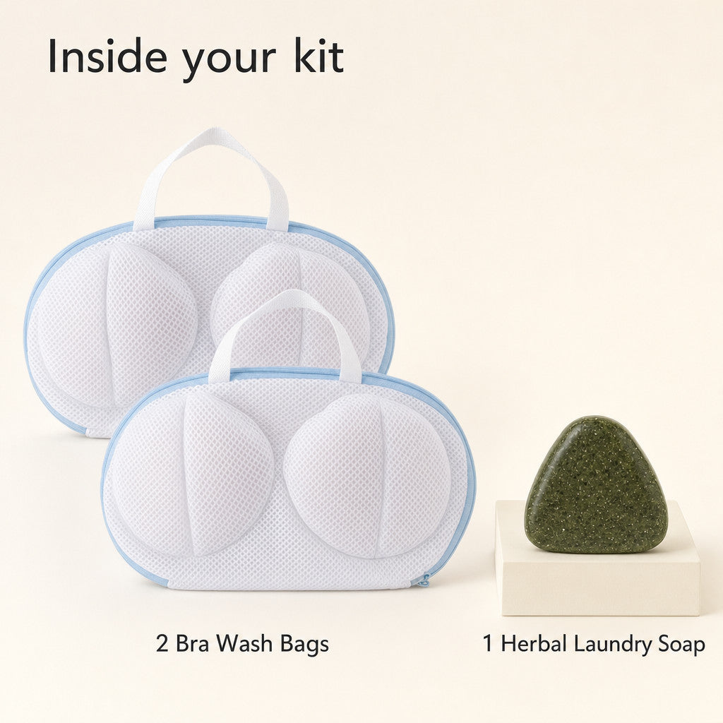 Kit contents: two matching white mesh bra wash bags with pale-blue zippers and one dark botanical-green rounded triangular herbal laundry soap.