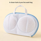Close-up of the original bra wash bag showing white mesh, pale-blue perimeter zipper and white fabric handle.