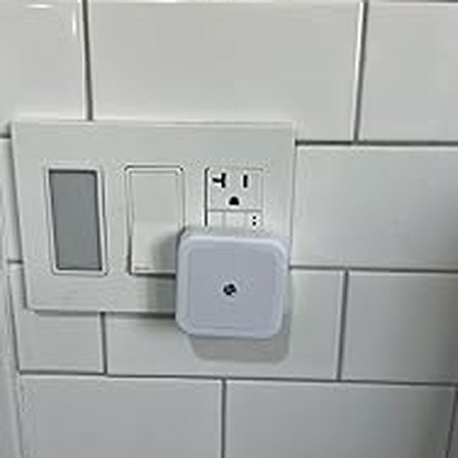Warm white square night light installed on a tile wall