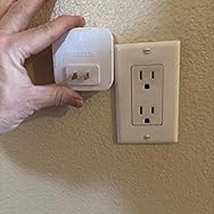 Hand installing the matching plug-in night light beside an outlet