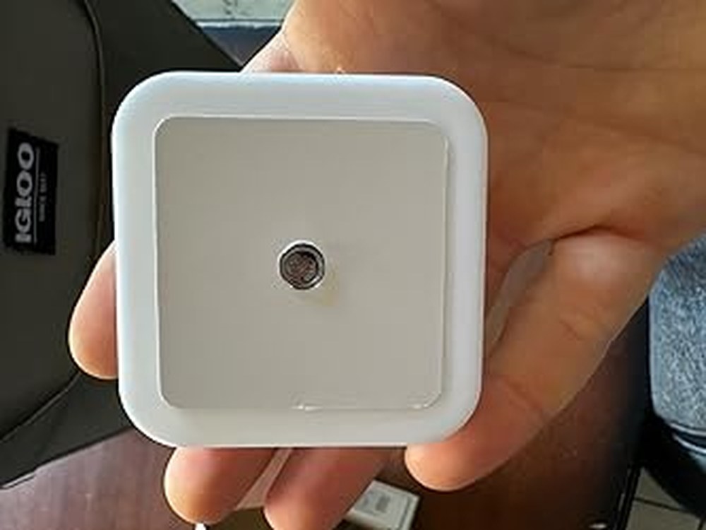 Hand holding the matching square plug-in night light