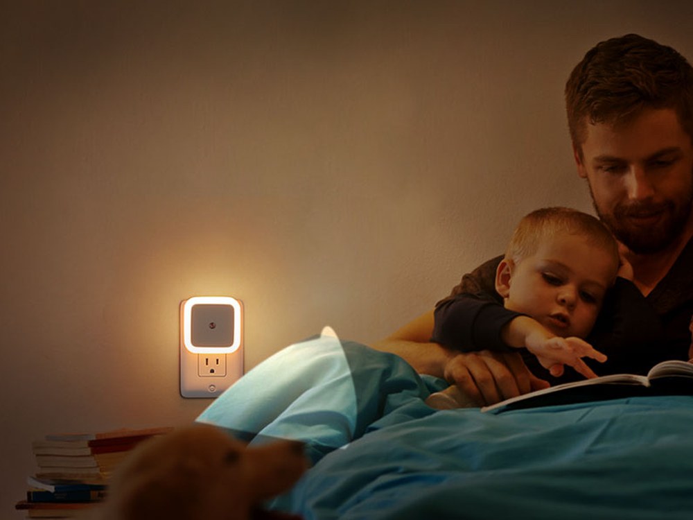 Warm white square night light used beside a family bed